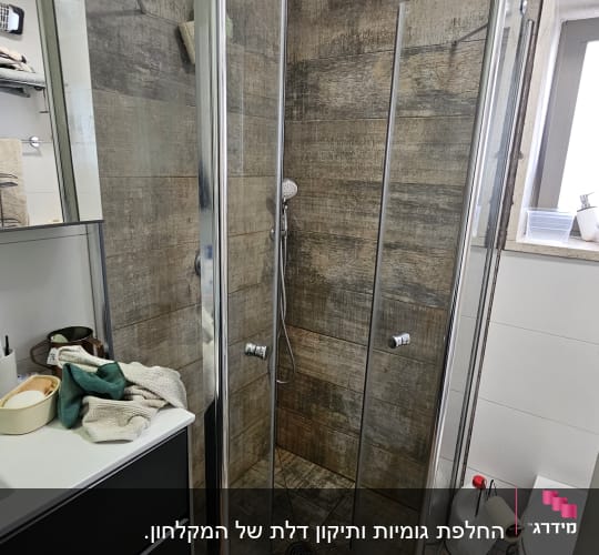 מקלחון זכוכית עם ראש מקלחת בחדר אמבטיה מודרני
